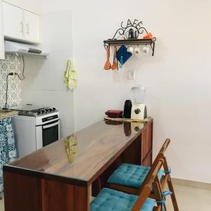 een keuken met een aanrecht en een blauwe stoel bij Apartamento em Lencois - Bahia No 106 in Lençóis