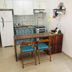 eine Küche mit 2 Stühlen, einer Theke und einem Kühlschrank in der Unterkunft Apartamento em Lencois - Bahia No 106 in Lençóis