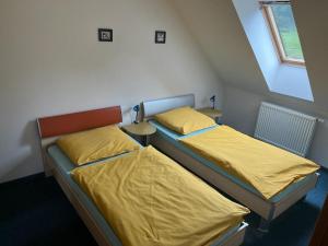 ビンペルクにあるApartment Hannyの小さな部屋のベッド2台(黄色のシーツ付)