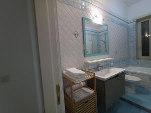 een badkamer met een wastafel en een spiegel bij Fifth Floor in Napels