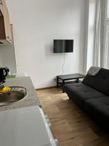 un soggiorno con divano nero di Apartament Mieszka I a Gniezno