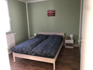 a bedroom with a bed with a blue comforter at Naturheilcamp Götzer Berge in Groß Kreutz