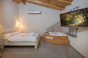 1 dormitorio con bañera, 1 cama y TV en סוויטות פנינת המעיינות en Reẖov