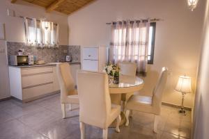 een keuken en eetkamer met een tafel en stoelen bij סוויטות פנינת המעיינות in Reẖov