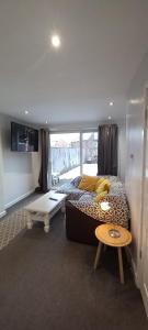 a bedroom with a bed and a table and a tv at Spacious 2 Bed, Free Parking, Free Wifi - Serene Homes Sheffield in Hillsborough