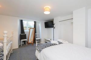 a bedroom with a white bed and a television at Spacious 2 Bed, Free Parking, Free Wifi - Serene Homes Sheffield in Hillsborough