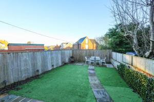 a backyard with a fence and a green lawn at Spacious 2 Bed, Free Parking, Free Wifi - Serene Homes Sheffield in Hillsborough