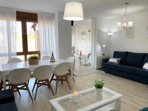 a living room with a table and a blue couch at "LAS CAMELIAS SOMO" un lugar para desconectar!! Vistas al MAR!! in Somo +45 photos