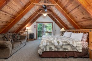 ein Schlafzimmer in einem Blockhaus mit einem Bett und einem Sofa in der Unterkunft Clark Cabin in Yosemite West