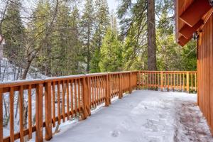 ein schneebedecktes Deck mit Bäumen im Hintergrund in der Unterkunft Clark Cabin in Yosemite West