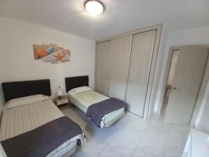 ロザスにあるRosesapparts Mairóのベッドルーム1室(ベッド2台付)、スライドドアが備わります。