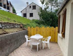 a table and chairs on a patio with a yellow fence at Ecueil des Neiges in Barèges