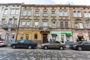 um grupo de carros estacionados em frente a um edifício em Куліша 15, апартаменти в центрі,ТЦ Форум,оперний em Lviv