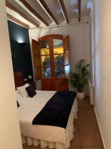 una camera con letto, finestra e pianta di Las Puertas Del Indiano a Relleu