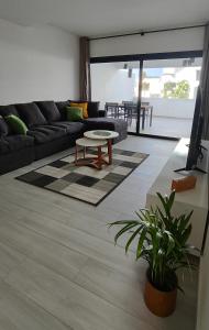 una sala de estar con un sofá y una mesa en Superior Apartment, Casilla de Costa, en La Oliva