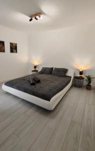 1 dormitorio blanco con 1 cama grande y 2 lámparas en Superior Apartment, Casilla de Costa, en La Oliva