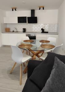 cocina con mesa de cristal y sillas blancas en Superior Apartment, Casilla de Costa, en La Oliva
