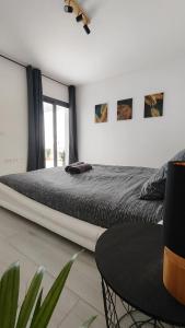 1 dormitorio con 1 cama grande y 1 mesa en Superior Apartment, Casilla de Costa, en La Oliva