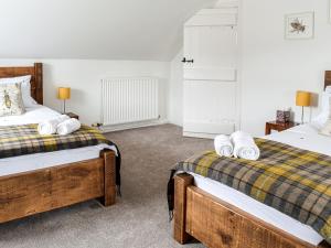 a bedroom with two beds with towels on them at The End Hoose in Whitsome