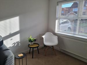a living room with a white chair and a window at The Appleleaf with Free Parking in Barton-upon-Humber