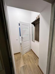 un corridoio con porta bianca e pavimento in legno di Apartament Mieszka I a Gniezno