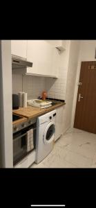 a kitchen with a stove and a washing machine at Résidence de lux tout confort 2 in Geneva