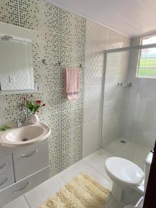 a bathroom with a shower and a sink and a toilet at Pousada Cantinho da Paz in Itatiaia +22 photos