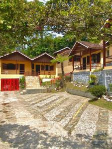 a yellow house with a red fence in front of it at Pousada Cantinho da Paz in Itatiaia