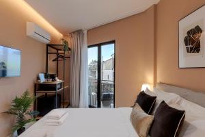 sypialnia z łóżkiem i dużym oknem w obiekcie Clyde Athens by Nin&Bau w Atenach