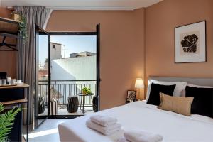 a bedroom with a bed and a balcony at Clyde Athens by Nin&Bau in Athens