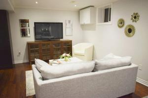 uma sala de estar com um sofá e uma televisão em Home Away From Home - Basement Studio Apartment em Toronto
