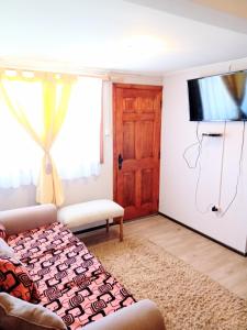 a living room with a couch and a flat screen tv at CABAÑA EN PUERTO VARAS in Puerto Varas