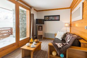 a living room with a couch and a table at Lagrange Vacances Les Balcons des Aiguilles in La Toussuire