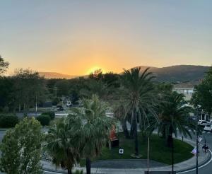 a sunset over a city with palm trees at Alamic in Grimaud