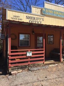 a small building with a sign on the front of it at Acorn Hideaways Canton Rustic Old West Frontier Suite in Canton