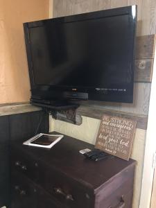a flat screen tv sitting on top of a dresser at Acorn Hideaways Canton Rustic Old West Frontier Suite in Canton