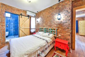 a brick walled bedroom with a bed and a red table at Kalkan - 2+1 - Full Sea View - Shavilla Han in Patara