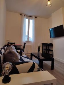 ein Wohnzimmer mit einem Sofa und einem Tisch in der Unterkunft La vie en blanc et noir Maisons-Laffitte in Maisons-Laffitte