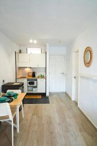 a living room with a table and a kitchen at Las Americas studio in Playa de las Americas
