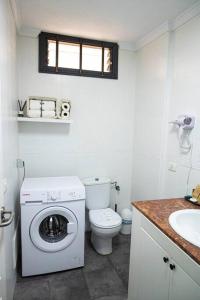 a bathroom with a toilet and a washing machine at Las Americas studio in Playa de las Americas