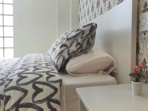 un letto con cuscini bianchi e neri e un tavolo di Apartamentos Carrillo 4 Ático a Santa Cruz de Tenerife