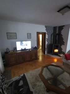 ein Wohnzimmer mit einem TV und einem Kamin in der Unterkunft Bjelasica Home in Kolašin