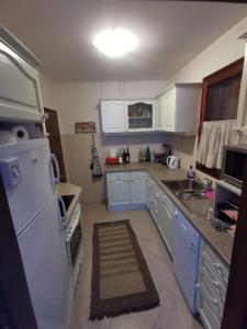 eine Küche mit blauen Schränken und einem weißen Kühlschrank in der Unterkunft Bjelasica Home in Kolašin
