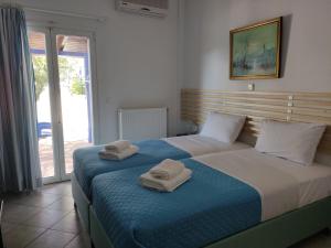 2 camas con toallas encima de ellas en un dormitorio en Villa Rosanna, en Plataria