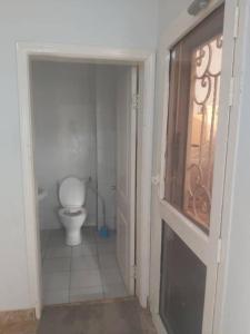 a bathroom with a toilet and a glass door at Muhammed Ceesay Villa in Old Yundum