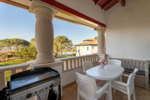 een veranda met een witte tafel en een grill op een balkon bij Atlantic Selection - Domaine de Bordaberry - Avec piscine et vue océan in Urrugne