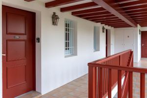 een hal met een rode deur en een trap bij Atlantic Selection - Domaine de Bordaberry - Avec piscine et vue océan in Urrugne +45 foto's