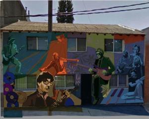 un mural en el lateral de un edificio con músicos en La casa de los murales en Avellaneda