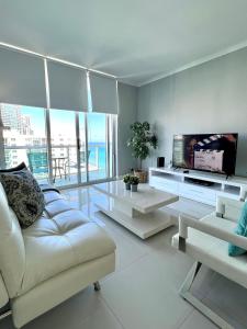 a living room with a white couch and a flat screen tv at Hollywood on Beach Apartment in Hollywood