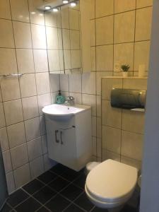 a bathroom with a white toilet and a sink at Grønnegade - tæt på Esbjerg C in Esbjerg
